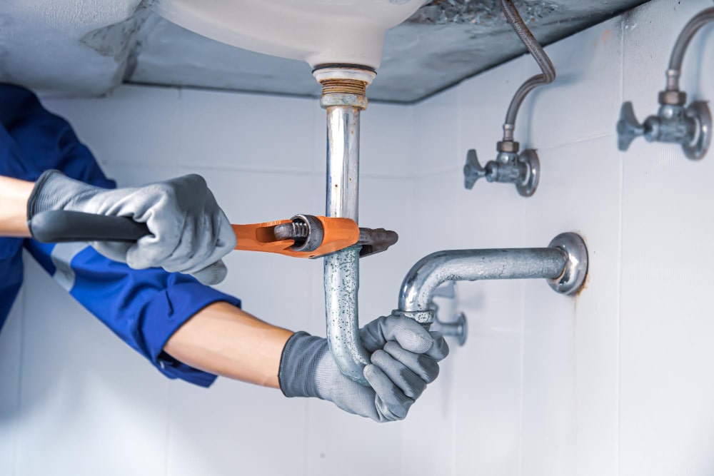 technician-plumber-using-wrench-repair-water-pipe-sink-min